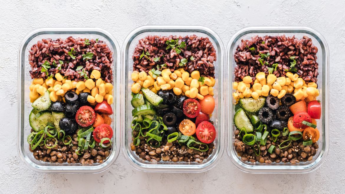 Image of three meal-prepped plant-based meals in glass containers.