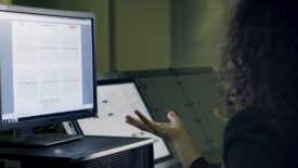 Image of a woman looking at data from a computer screen
