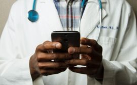 Image of a doctor holding a phone.
