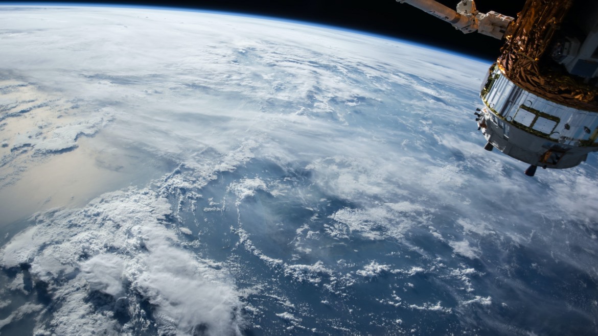 Image of the earth from space with a satellite orbiting it.