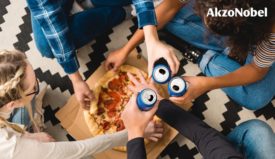 People holding cans above a pizza