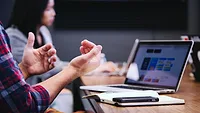 Someone talking with their hands in a boardroom meeting. Someone talking with their hands in a boardroom meeting.