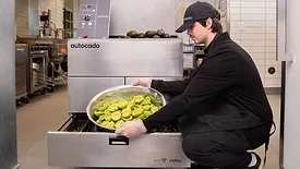 Image of a person putting avocados in the Autocado cobot.