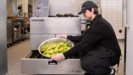 Image of a person putting avocados in the Autocado cobot.