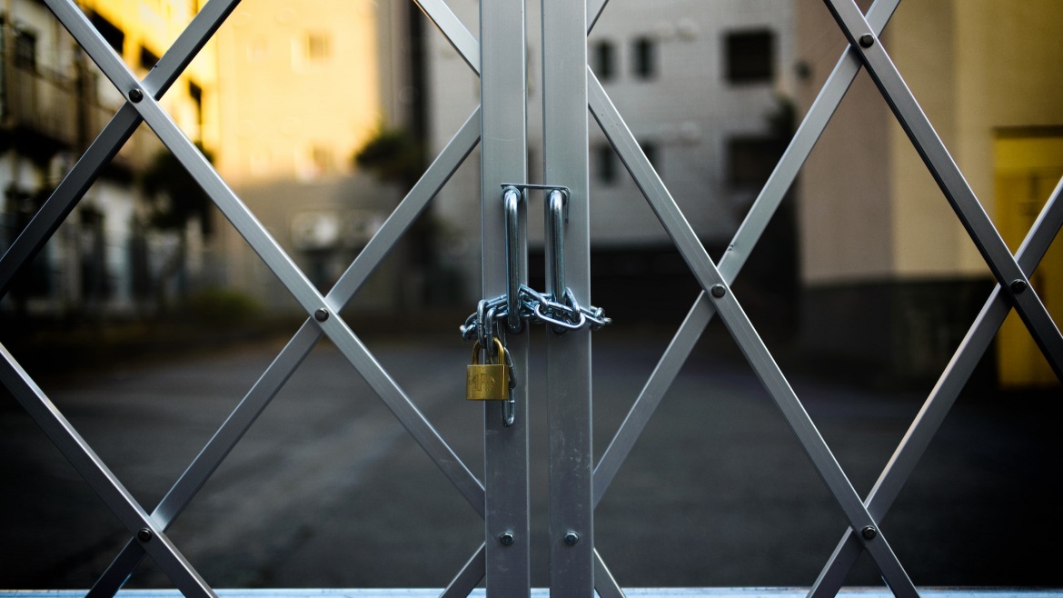 Image of gold lock chained to steel doors