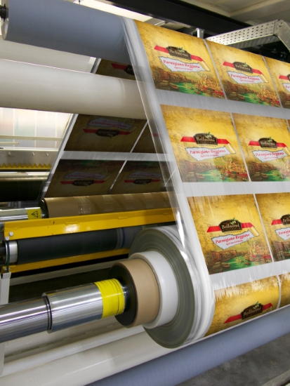 Custom printed packaging on rolls going through machine in factory