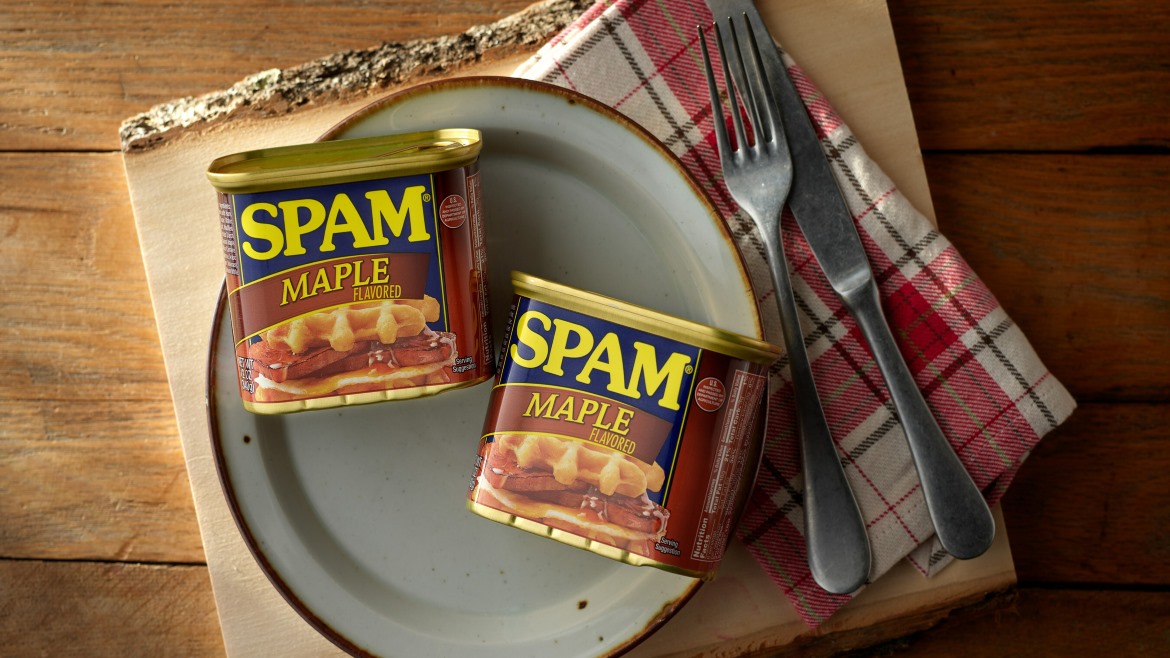 Two SPAM maple flavored cans next to a plate with a fork and knife