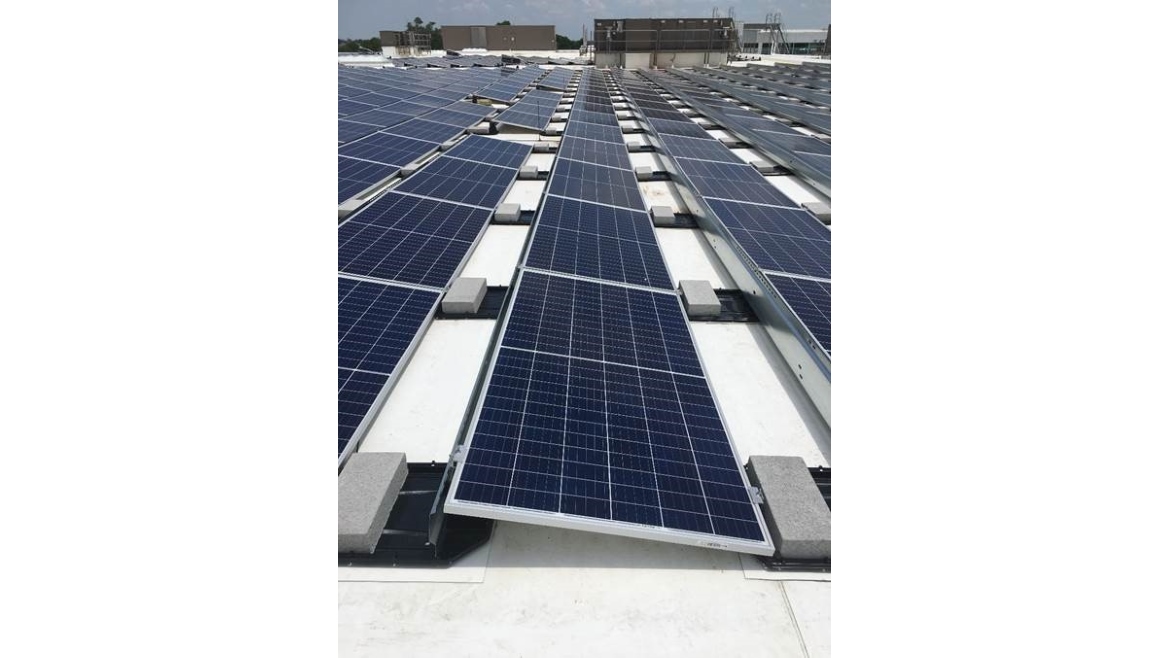 Solar panels lined up in rows across a rooftop