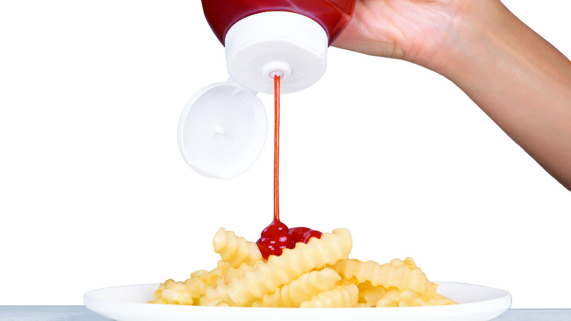 Squeezing ketchup on fries