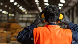 Worker holding ear protection