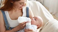 Mother bottle feeding baby