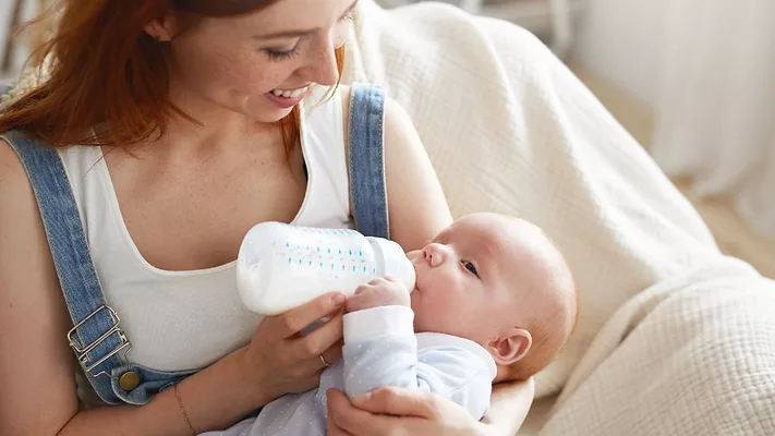 Mother bottle feeding baby