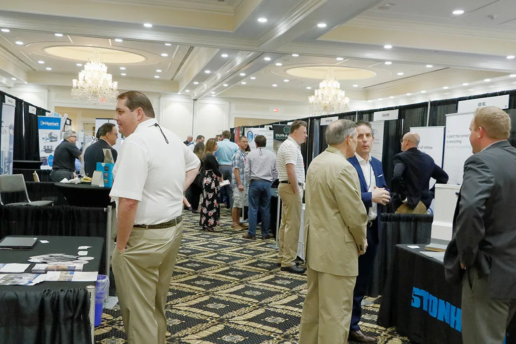 Exhibit booths with exhibitors and attendees at the Food Automation & Manufacturing Symposium and Expo set up in a ballroom at the Doral Resort in Miami.