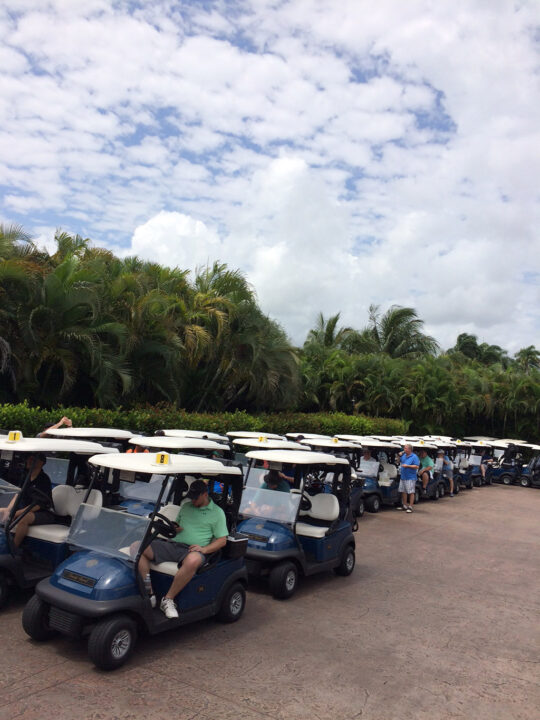 A line of golf carts lined up with Food Automation & Manufacturing Symposium and Expo attendees outside the Doral Resort in Miami, Florida.