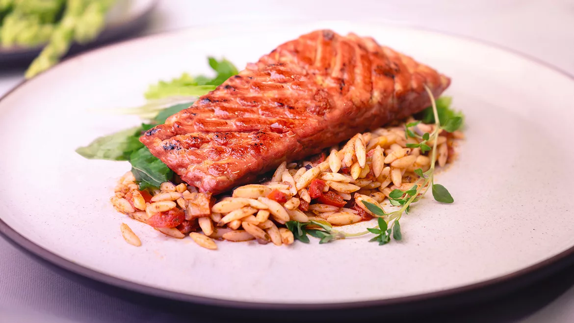 Austria-based Revo Foods’ 3D printed salmon fillet made from alternative proteins on a bed of rice on a white plate.