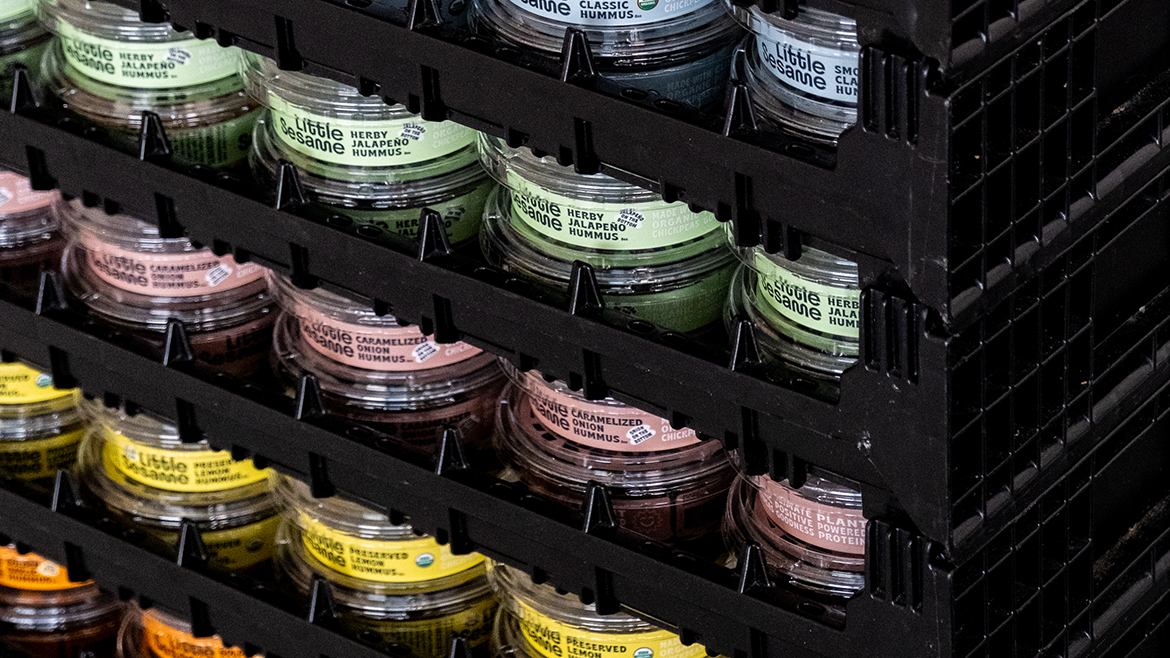 Little Sesame hummus packages in a variety of flavors inside crates.