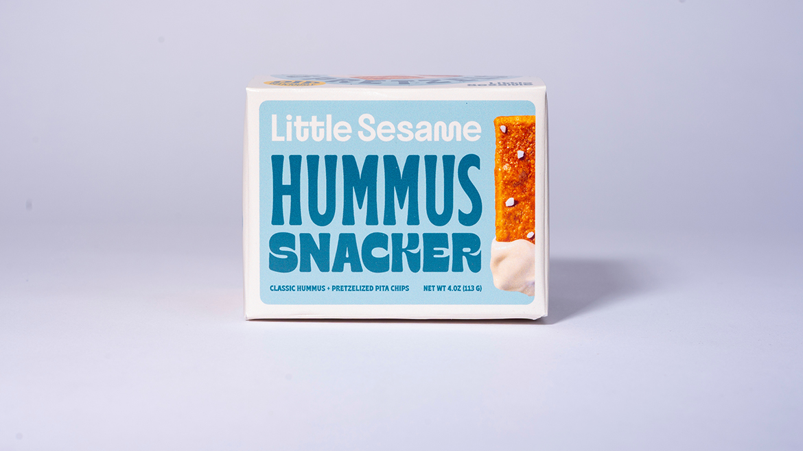 A box of Little Sesame Hummus Snacker on a lavender-colored background.