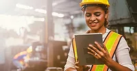Working in safety gear on her tablet Working in safety gear on her tablet.