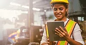 Working in safety gear on her tablet Working in safety gear on her tablet.