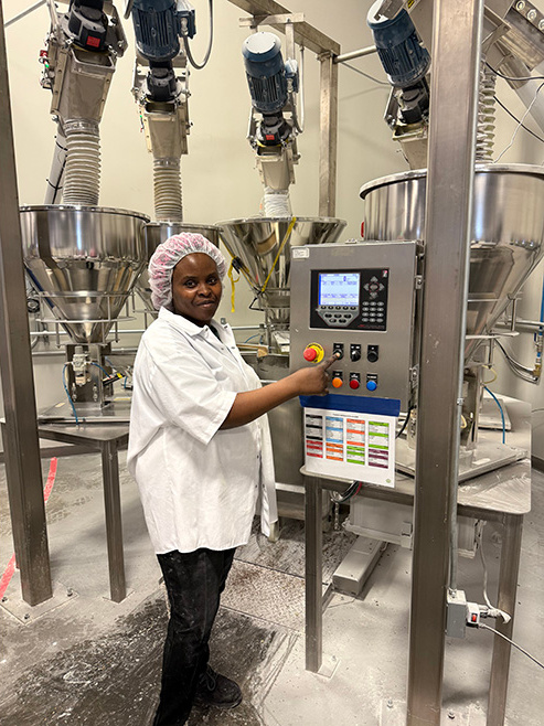 A Top Seedz Employee standing next to equipment.