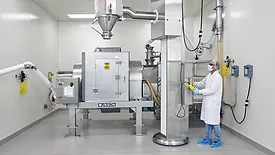 Worker in safety clothing working with a 40-cu.-ft. capacity Munson Model 700-TS-40-SS rotary batch mixer.