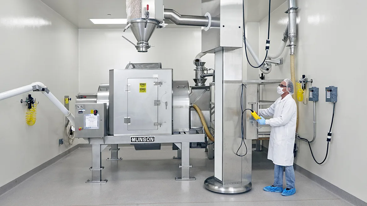 Worker in safety clothing working with a 40-cu.-ft. capacity Munson Model 700-TS-40-SS rotary batch mixer.