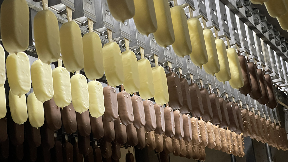 Rows of hanging bars of Magnum ice cream in white chocolate and chocolate.