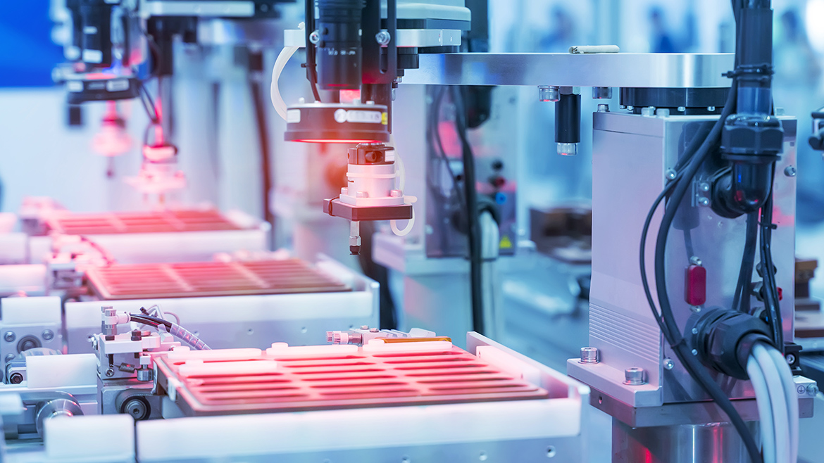 Automated industrial machinery uses robotic vision systems to inspect components on a manufacturing line.