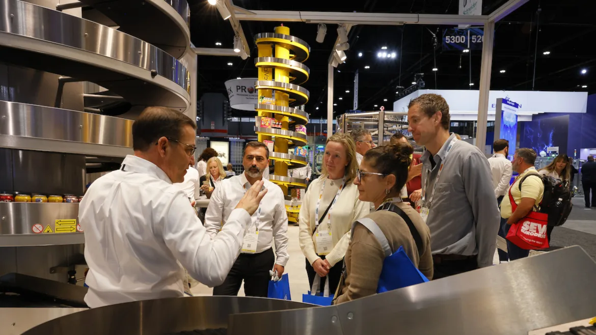 An event host is presenting to a group of PACK EXPO event attendees.