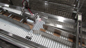An automated diverter feeds bars to each of the lineâ€™s shrink wrappers on conveyors