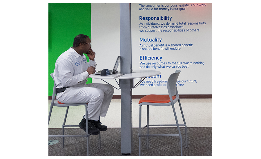 Image of a worker using a laptop in the breakroom of a facility