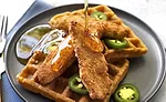 Rebellyous chicken tenders on top of waffles and jalapenos and syrup
