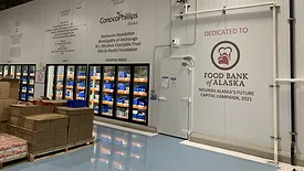 Interior of the food bank with the logo of ‘The Alaskan Food Bank’ on a wall.