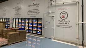 Interior of the food bank with the logo of ‘The Alaskan Food Bank’ on a wall.