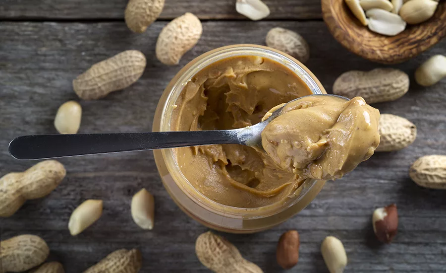 Spoonful of peanut butter on peanut butter jar