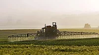 Farmer spraying field