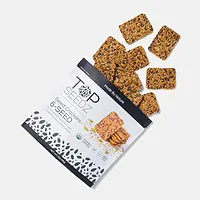 An open package of Top Seedz crackers with some spilling out of the bag, on a white background.