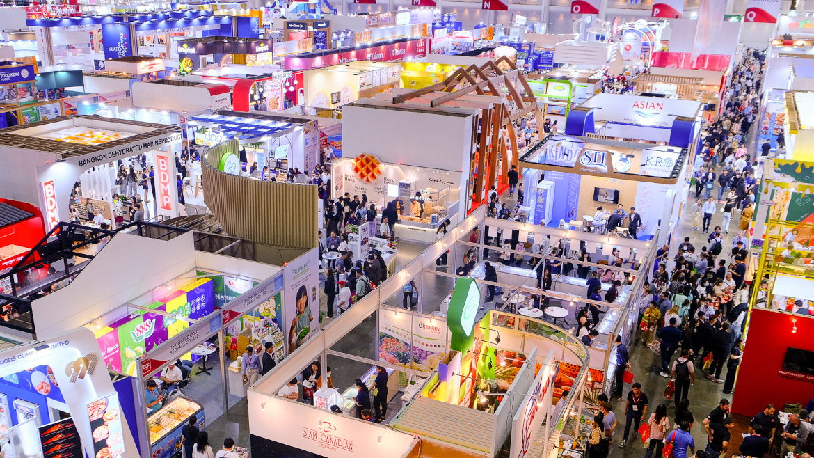 May 30 overhead shot of THAIFEX-ANUGA event floor showing event booths and attendees walking down an aisle.