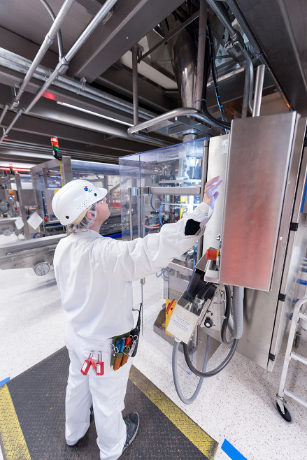 Employee in white safety gear checks ERP system.